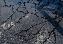 Close-up of cracked asphalt being sealed