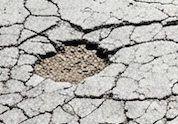 Pothole in cracked asphalt needing repair
